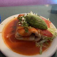Vegan smothered burrito with the mild (orange) sauce. SO GOOD. Also gluten free tortilla (it was a few corn tortillas rolled together. Delicious!!!!)  at Morenita's in Idaho Falls