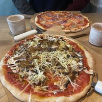 Vegan pizza with mushrooms, and another one with vegan bacon  at Casa La Familia in Vilnius