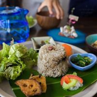 Lunch set featuring brown rice and pickled plum, lotus root, greens, eggplant, komatsuna, miso soup, and tofu.  at Imacoco in Okinawa