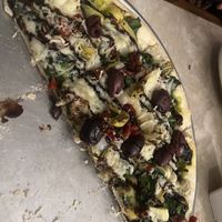 Vegan pizza. Vegan pesto, Kalamata olives, artichokes, Daiya cheese, spinach, basil, onion, sun dried tomatoes, balsamic vinaigrette drizzle.   at John's Restaurant in Rockford