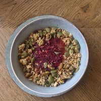 Porridge with homemade rhubarb compote and rose, topped with pistachios, homemade granola and pumpkin seeds at Brochan in Edinburgh