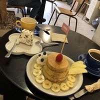 Pancakes with fruit and vegan cream, an americano, Oreo cake and a cappuccino  at Chillin' Cafe in Madrid