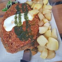 Cachopo (cheese-filled cutlet) with bolognese and pesto at El Manglar in Oviedo