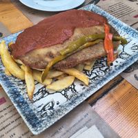 Cachopo tradicional con patatas fritas y tiras de pimiento asado at El Manglar in Oviedo