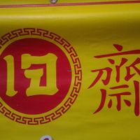 Red and yellow sign for vegan food all over thailand at Ban Khrua Jai in Trat