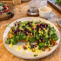 Avocado toast met kerrie hummus, kikkererwten en rauwkost  at By-Kees in Heerenveen