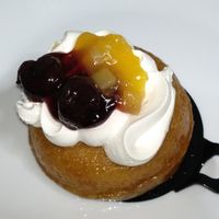 Vegan baba (sweet, yeast-based cake soaked in syrup with whipped cream and fruit in jelly) at Pasalidis in Thessaloniki