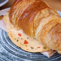 Croissant vegano complete (tomato, vegan mortadela, vegan melted cheese), served warm at Mimimi in Granada