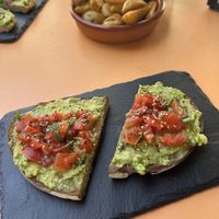 Avocado toast with tomato & seeds, & potato wedges.   at Roots in Tenerife