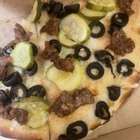 Gluten free vegan pizza- violife cheese, pickles, black olives and beyond burger  at Pizza Palace in Milford