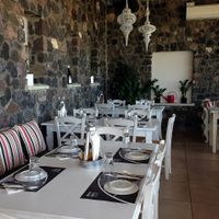 Comfy seating area with variety of herbs planted at the window seating area at Aroma Avlis in Santorini