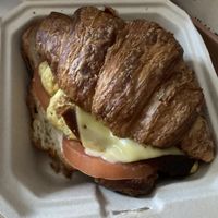 Breakfast croissant sandwich with added tomato and avocado  at Orchard Grocer in New York City