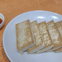 Fried black tofu 검정두부부침 served with seasoning sauce at Baengnyeonok - 백년옥 in Seoul