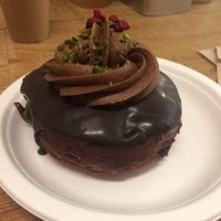 Vegan raspberry “Nutella” doughnuts with chocolate mousse on top, garnished with raspberry bits and crushed pistachios.  at Chök in Barcelona
