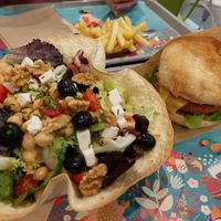 Greek salad, french fries in the back, burger 🤤 at Khambú Quart in Valencia
