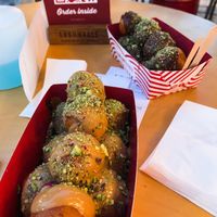 Vegan praline chocolate filling topped with peanut butter and pistachios at the front. Vegan cherry filling with bitter chocolate topping and pistachios at the back! at Lukumades in Athens