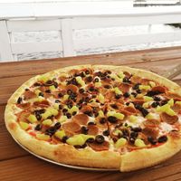 Vegan pizza with pepperoni, sausage, pineapples, and black olives. at Nags Head Pizza Company in Nags Head