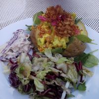 Baked potato with chicken-seitan, a delicious curry-inspired sauce with pickles and fried onions. Big salad on the side at Ebbas in Lund