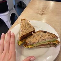 Frittata sandwich.  Woman’s hand for scale.  at Nourish Cafe in San Francisco