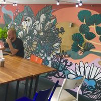 Outdoor seating area with graffiti art at Padoca Vegan in Sao Paulo