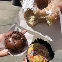 (Top) French toast doughnut, (bottom) zucchini chocolate cake doughnut, passion fruit ice cream in a charcoal waffle cone  at Doe Donuts in Portland
