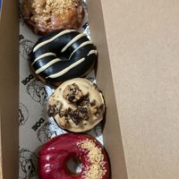 From top: bourbon apple fritter, black sesame, peanut butter cup, blackcurrant buttered toast at Doe Donuts in Portland