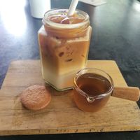Iced latte with oatmilk, served with a ginger biscuit. at Rainbow Cafe in Ella