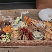 Appetizer baskets - hummus, eggplant spread, vegetable spread, gluten free sourdough bread, crackers, nachos, fruits, vegetables and nuts  at Tökmag Vegan Street Food in Budapest