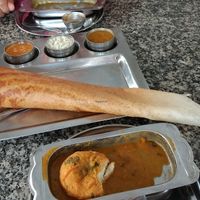 Paper dosa (made with rice flour). Very thin and crispy with 4 different dipping sauces. The white sauce was coconut based. at Annapoorna Restaurant in Dubai