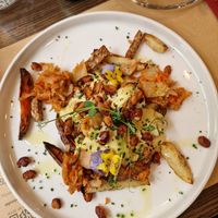Loaded Potatoes with Kimchi, fried beans, buckwheat Tempeh, mustard cheesy sauce at Bistro Maha in Ljubljana