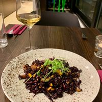 Black rice risotto and local white wine at Bistro Maha in Ljubljana