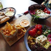 Salad bowls with bread and fries and vegan dips at Bar Cali in Nijmegen