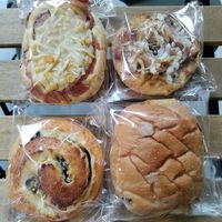 Clockwise from top left: bacon, cheese, and corn bun, cheese and ham mini pizza, lemon cake stuffed in a cherry bun, and olive, cheese, and jalapeno scroll at HiPizza in Taipei