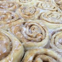 practicing our vegan carob cinnamon rolls drizzled in almond icing  at Radha Govinda's Buffet in Denver
