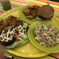 Happy cow burger with oven potatoes and guacamole salad. at Sara Green - Vegan Bistro in Bucharest