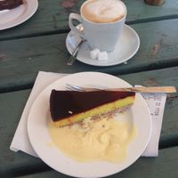 Lemon curd cake with vanilla sauce and an Oatly cappuccino. Both delicious at Parksnackan in Uppsala