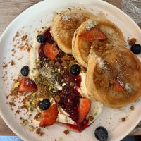 Spelt Pancakes with Forest Fruit Sauce, Sour Cream and Pistachio Lotus Crumble  at Happy Bean in Prague