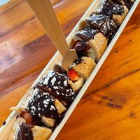 VEGAN ROLLED PANCAKE - with strawberries, bananas, chocolate sauce and powdered sugar. at The Happy Pig Pancake Shop in Amsterdam