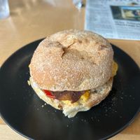 Breakfast sandwich on dos hermanos English muffin with vegan cheddar, bacon, mamas lil peppers, and garlic dill aioli   at Jet Black Coffee Company - Gateway in Portland