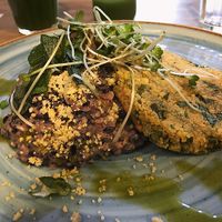 Risoto de Arroz Negro com queijo de castanhas cremoso, alho poro e cogumelos acompanhado de Medalhão de Grão de Bico e Couve com Crumesão at Raw Porto Alegre in Porto Alegre