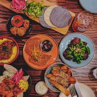 Selection of small plates including cauliflower tacos, artichoke arancini, mushroom ragu with polenta, beetroot ravioli, kimchi pancakes, herb & parm chips and celeriac shawarma at The Tipsy Vegan in Cambridge