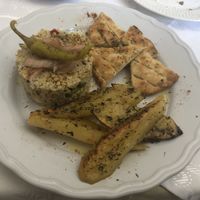 Potatoes, pita bread, and some sort of off the menu dish with couscous, split peas, and peppers. 😋 at Candouni in Santorini
