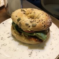 Bagel with hummus, avocado, tomato, and rocket at Holy Donut - Vokiečių in Vilnius