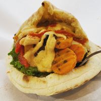 Full falafel sandwich with hummus, crazy carrots and chili chili bell bell. Topped with spicy tahini sauce. at Falafel Brothers - Minato in Tokyo