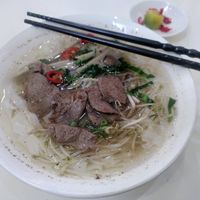 Big bowl of phở with mock beef, rice noodles and veggies. Lime and chili on the side. at Loving Hut - Ba Dinh in Hanoi