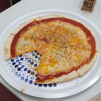 The pizza looked so good, that i had to take a bite before taking a picture. Pizza with three cheeses.  at Pizzeria La Faina in Malaga