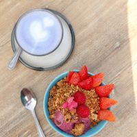 Dragonfruit smoothie bowl with granola & berries + butterfly latte  at Farm Girl Cafe in West London