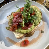 Avocado toast on sourdough w pickled onion, tomatoes & had potato wedges underneath   at Lemon Leaf in Kinsale