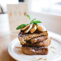 FRENCH TOAST- Delicious slices of bread are soaked in a mixture of almond milk and organic sugar, 
then pan-fried until they turn crispy on the outside. To top it all off we add a pile of sautéed bananas sprinkled with cinnamon, a drizzle of Canadian maple syrup & homemade coconut whipped cream. at Chickpea Restaurant in Vancouver