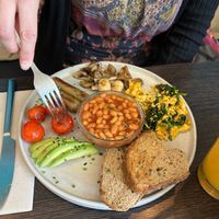Brunch plate with scrambled tofu, mushrooms, sausages, white beans, bread, grilled tomatoes and avocado.  at Goji Lounge Cafe in Lagos